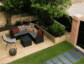 Terrasse en bois avec salon de jardin et massif fleuri à Saint-Malo
